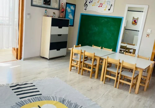 İlk Deneyim Anaokulu’nda müzik panosu ve çocuk çalışma masalarının bulunduğu sınıf